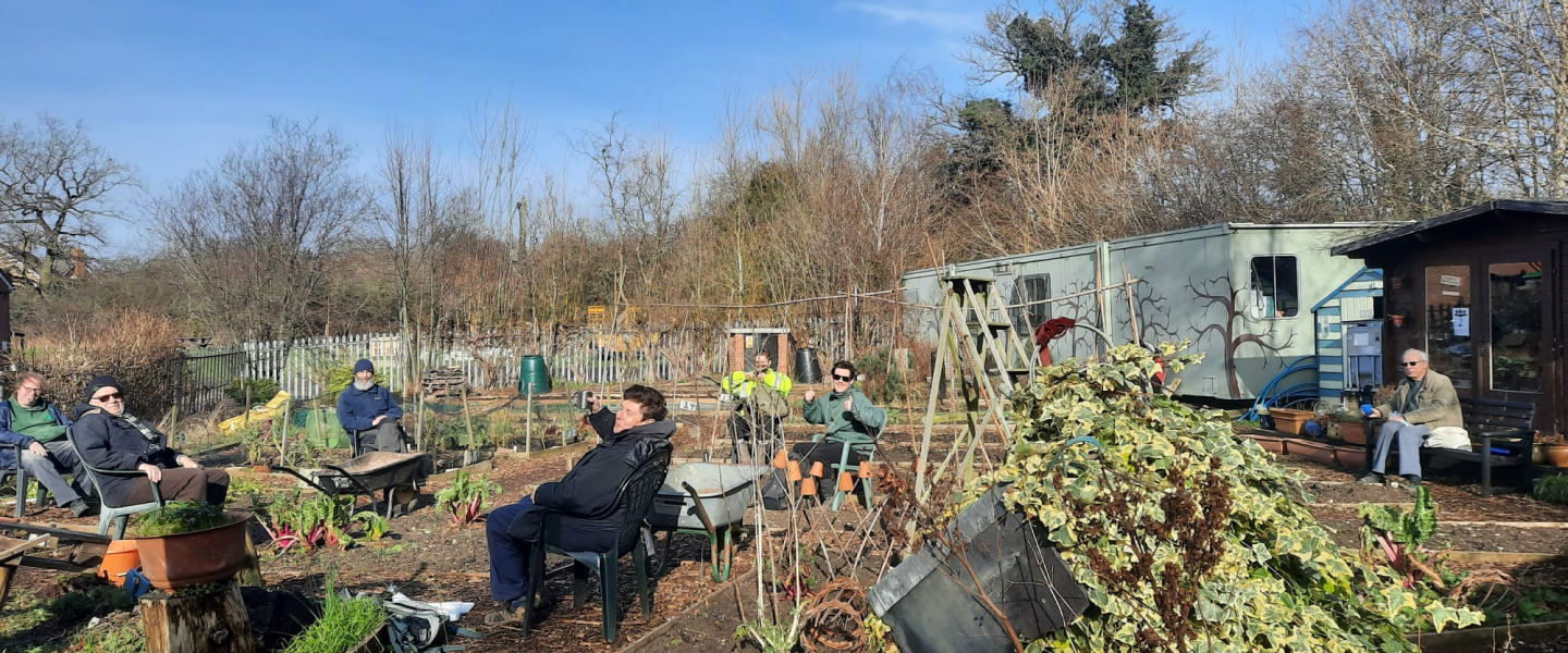 A group of Earthworkers in the gardens having a tea break