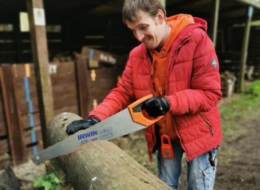 An Earthworker sawing a log