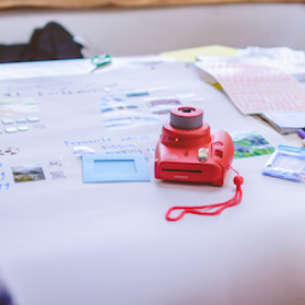 A close-up angle of a table containing various items including a polaroid camera