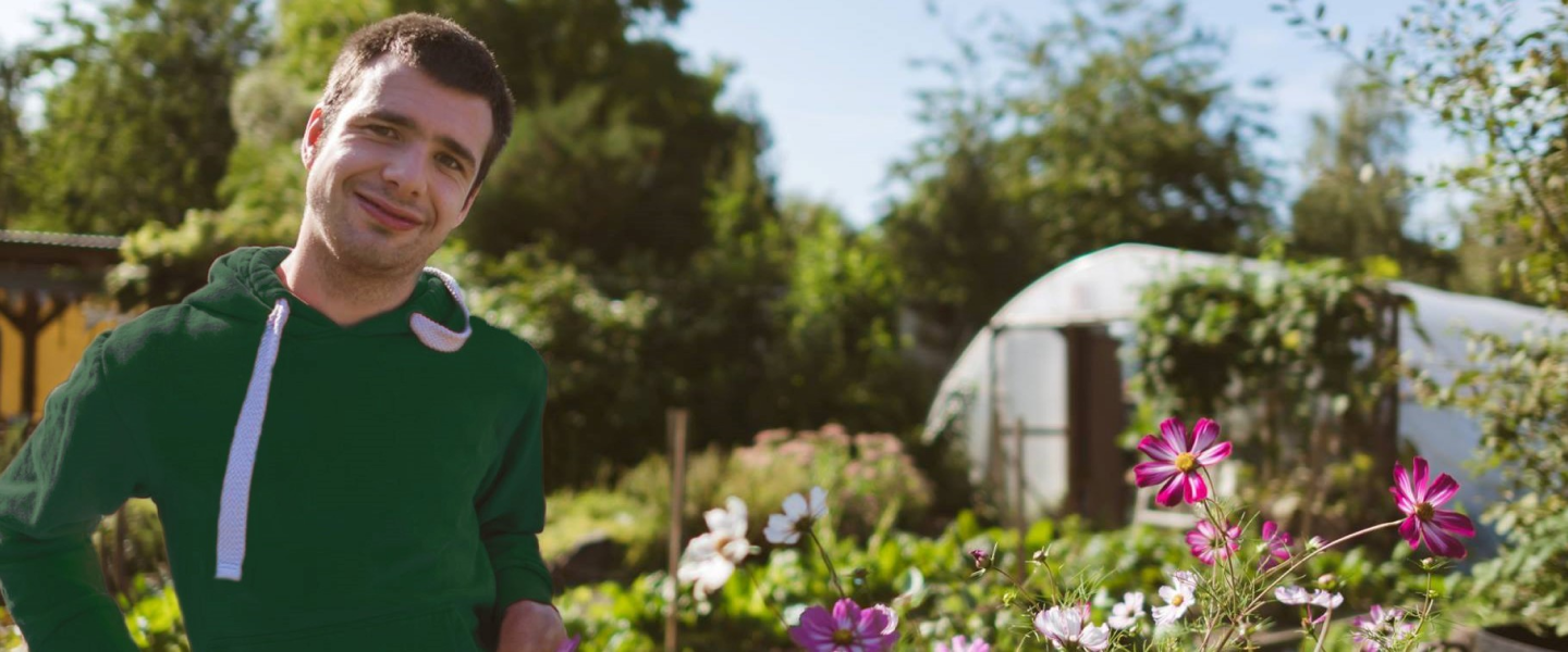 An Earthworker smiling in the Fairy Gardens in the sunshine