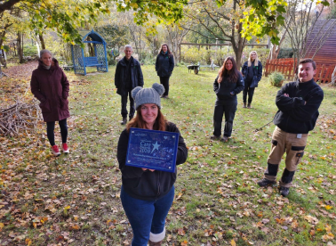 Our staff members team in the garden, holding up the Hertfordshire Care Award Outstanding Achievement Award 2020