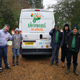 Five Earthworkers beside the Earthworks on Wheels van