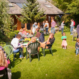 A group of people gathered in the gardens, some sat in clusters