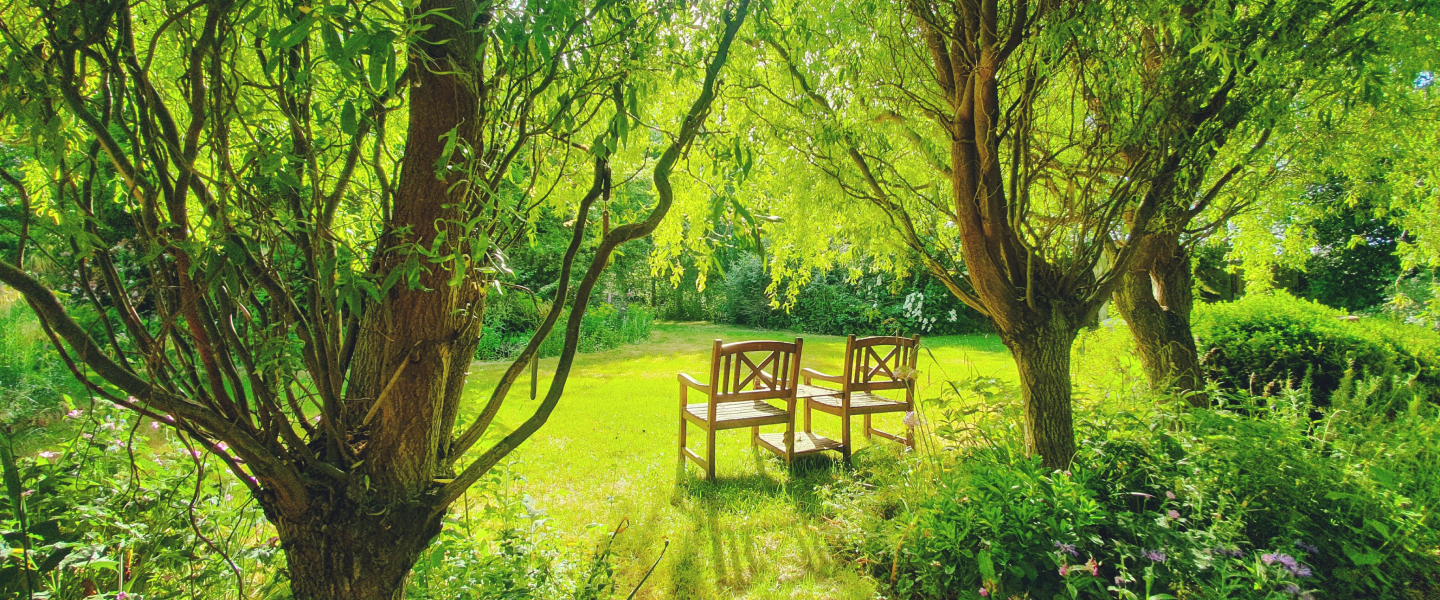 Two wooden chairs with a small table in the middle of our gardens