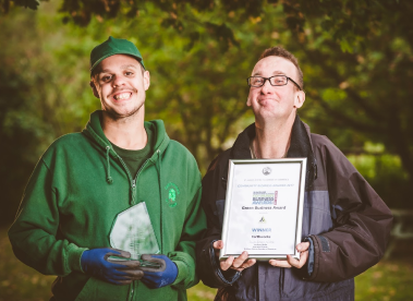 Two Earthworkers holding up the St Albans Community Green Business Award